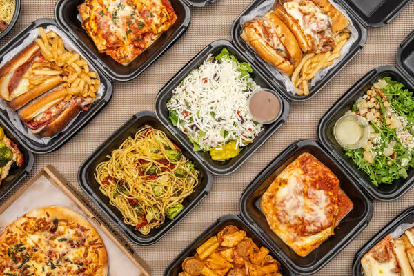 A variety of fresh catering lunch boxes — pasta, lasagna, salads, sandwiches and pizza